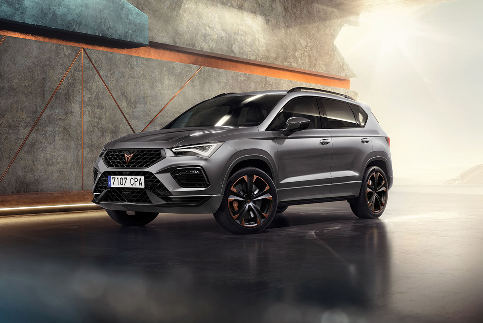 Cupra Ateca kerevärviga Graphite Grey, modernsesse tööstuslikku keskkonda pargitud sportlik ja kompaktne linnamaastur. Autol on aerodünaamiliste joontega välisdisain, LED-esituled ning erilised vasksete aktsentidega valuveljed. Taustal olev geomeetriline seinakujundus moodustab kauni kontrasti elegantse autodisainiga.